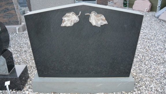 Sort granit mindesten med bronzeblade som dekoration